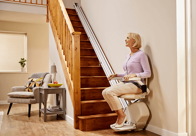 Lady using stairlift on straight staircase